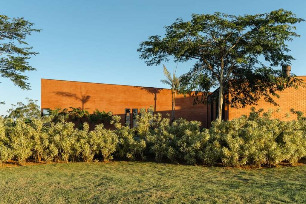 Side view of the parallel architectural blocks of Casa Plateau nestled within lush greenery.