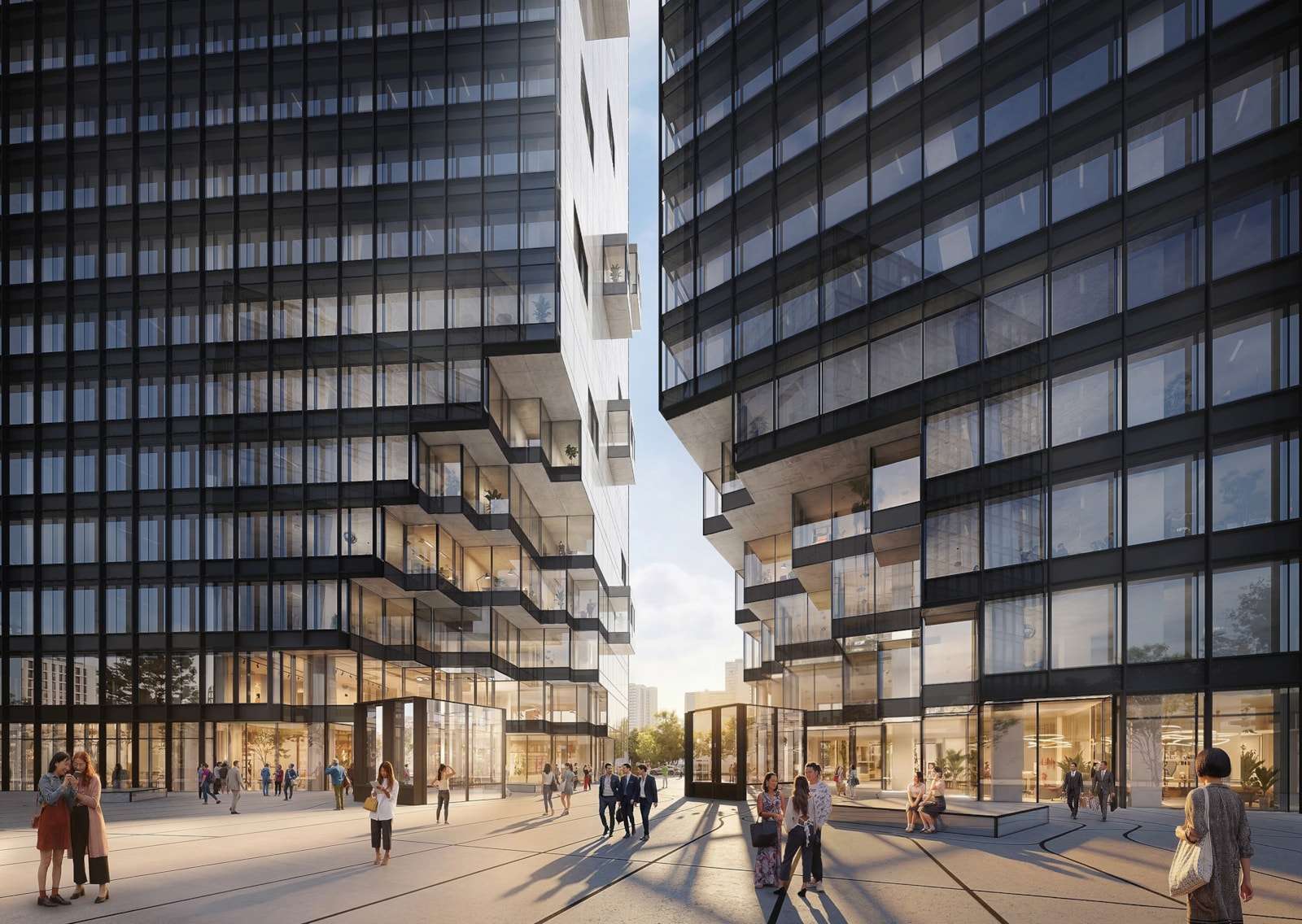 Pedestrian plaza between two contemporary office towers with stepped glass facades at ground level.