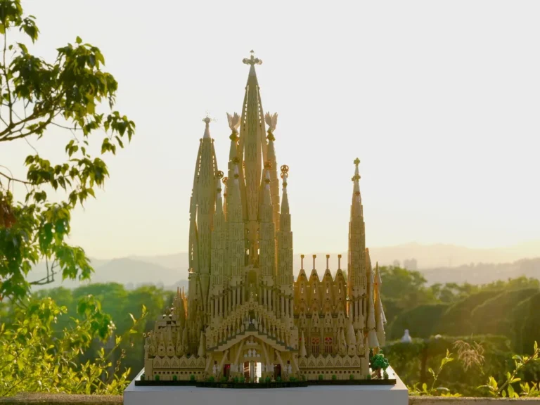 A completed LEGO Architecture model of the Sagrada Família basilica displayed outdoors against a sunlit landscape.
