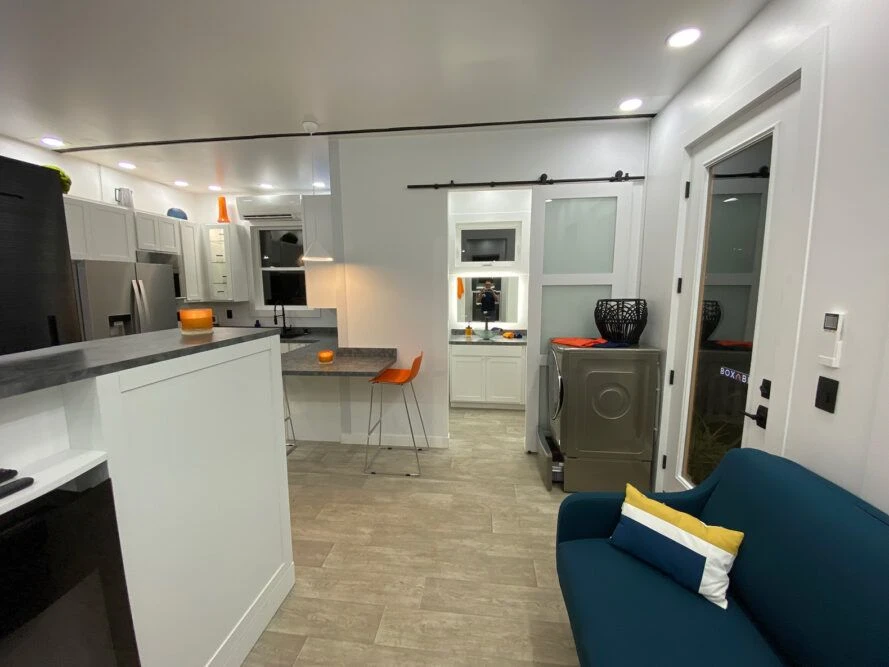 Interior perspective from the living area looking toward the kitchen counter and bathroom entrance.