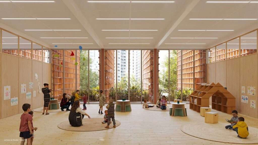 A well-lit interior classroom with wood floors, low millwork, and expansive glazed fenestration looking toward the facade.
