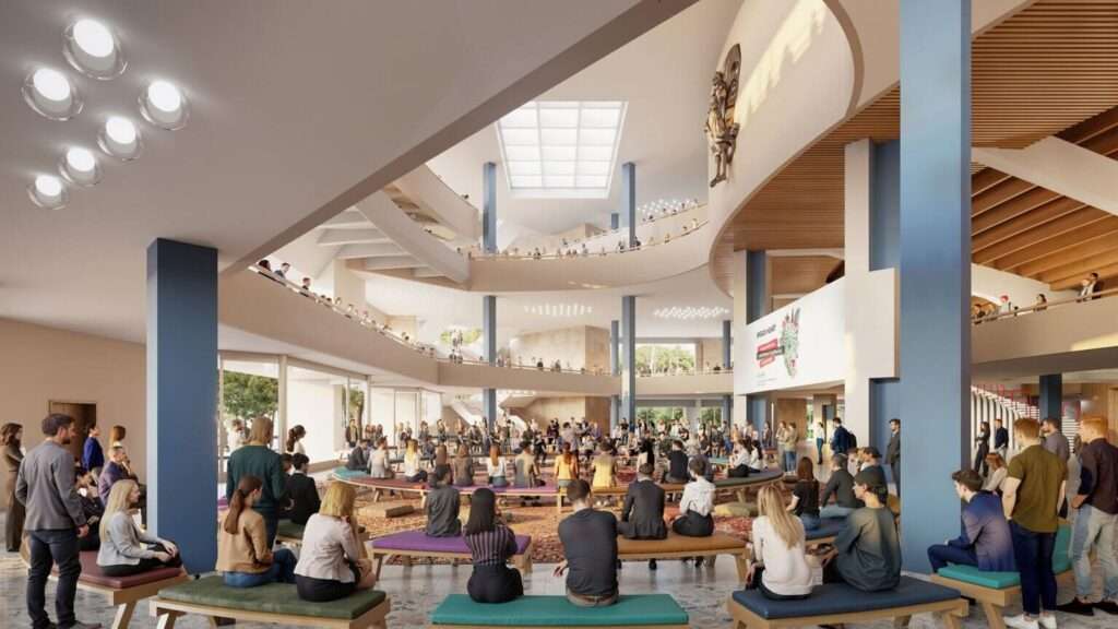 Interior view of a multi-level atrium with a circular seating area where people gather.