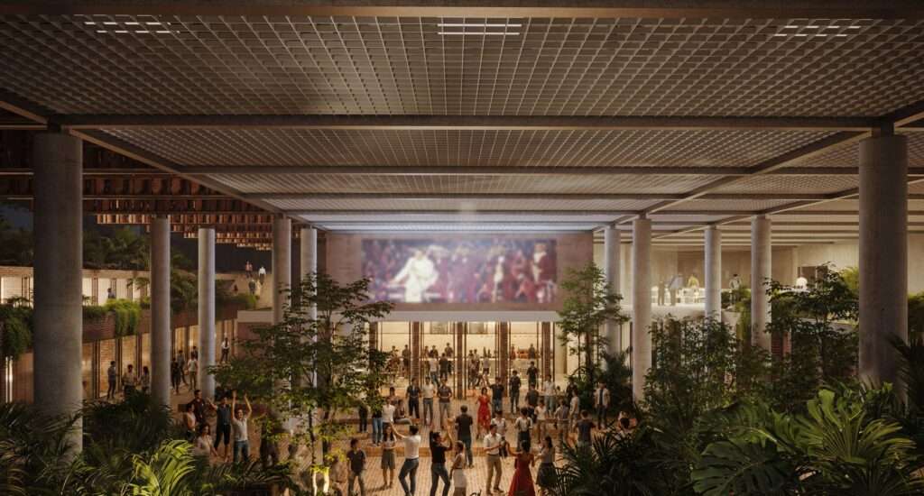 Night view of a lower-level open events area beneath a grid ceiling structure filled with people.