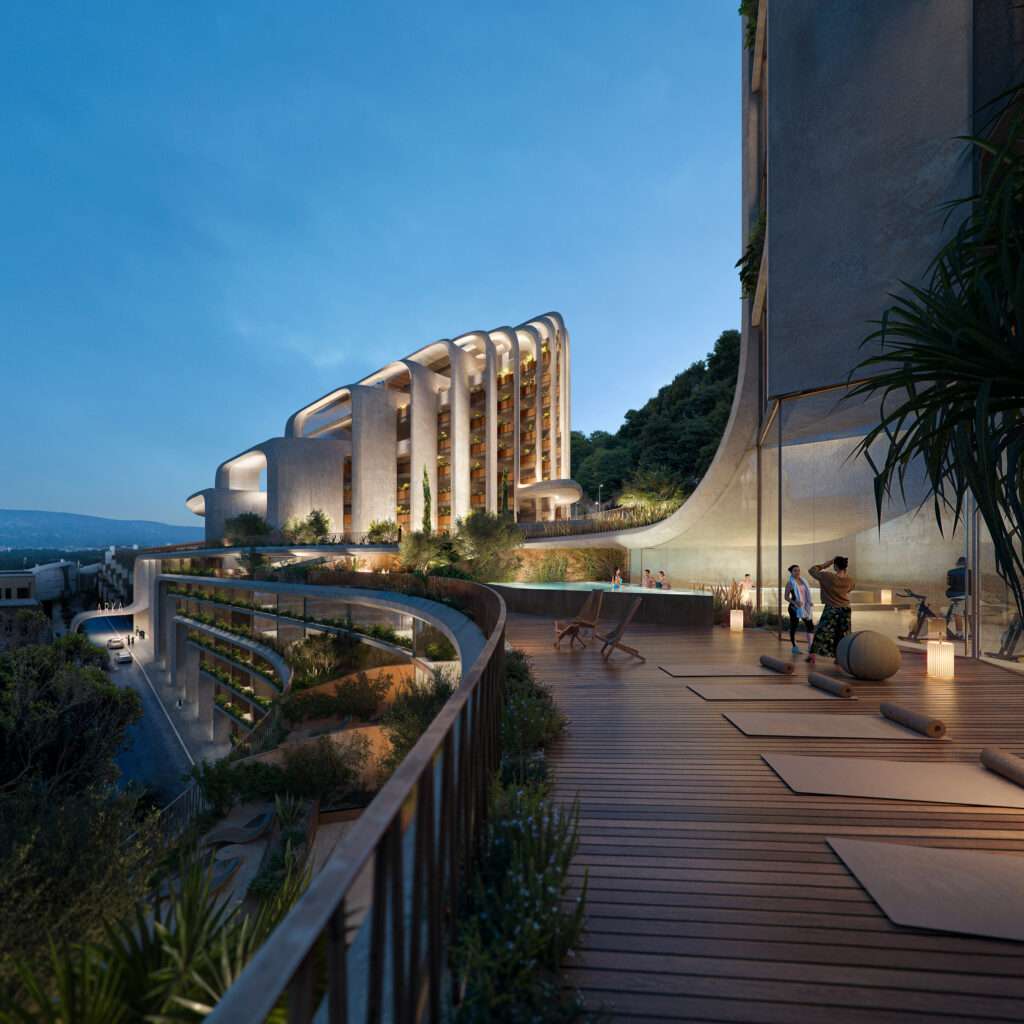 A wide outdoor wooden fitness deck at dusk overlooking a curved terraced concrete building lit up at night.