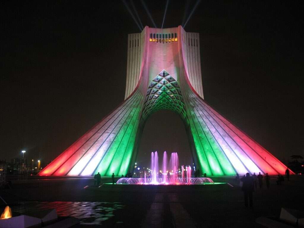 Symmetric eye-level shot of the main portal of Azadi Tower, detailing the network of interlocking stone ribs within the central archway.