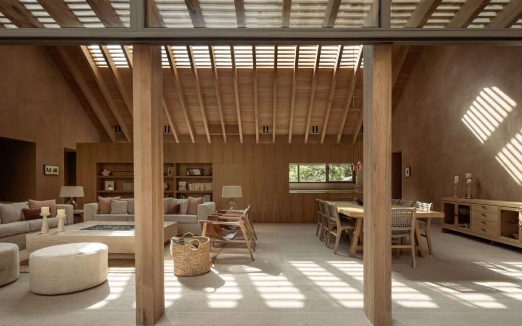 View from a bedroom window looking onto a landscaped garden courtyard with a wooden lounge chair on a concrete patio.