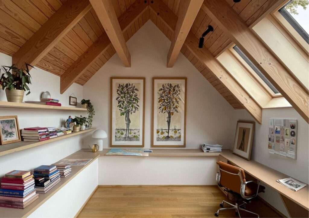 Upper loft office space in Day's Inlet House with natural wood vaulted ceilings, skylights, and a long built-in desk.