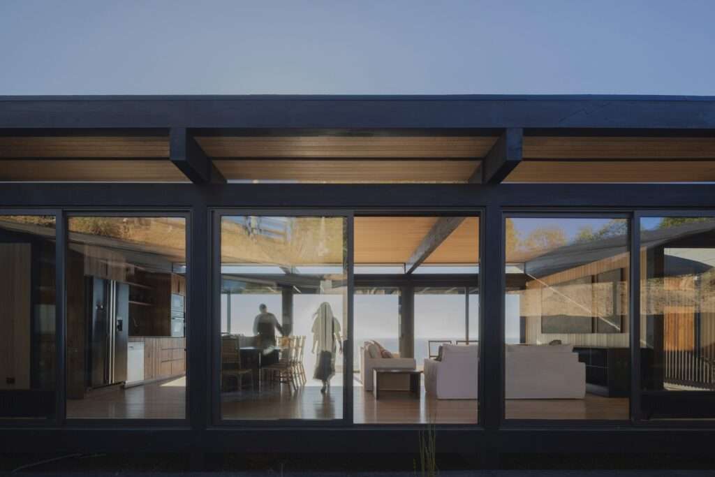 Exterior view of the Matanzas Beach House glass facade showing the open living area and internal courtyard.