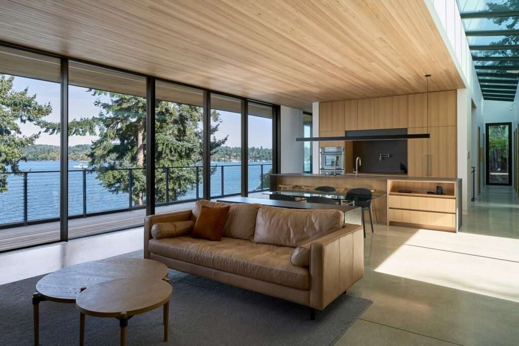 Open-plan living and kitchen area at Layer House with floor-to-ceiling glass overlooking the ocean.