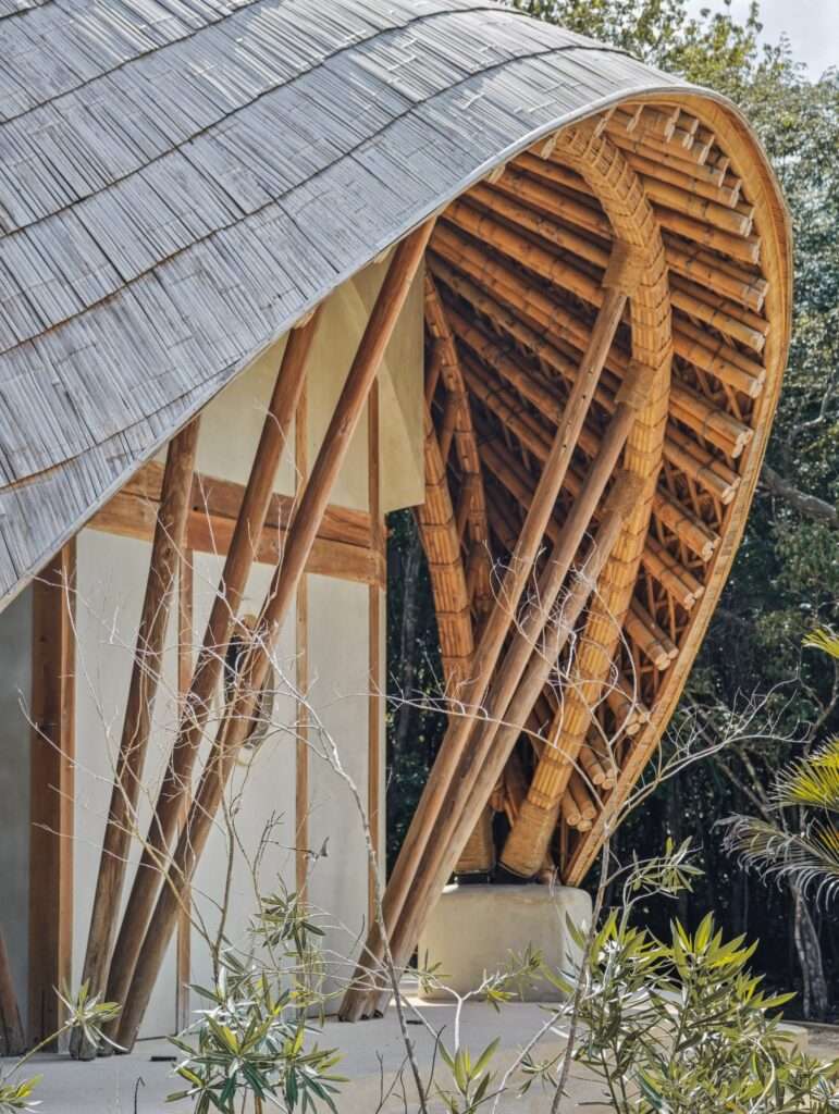 Close-up architectural detail of CORA Villa's roof extension, featuring complex bundled bamboo columns and overlapping thatch-like bamboo tiling.