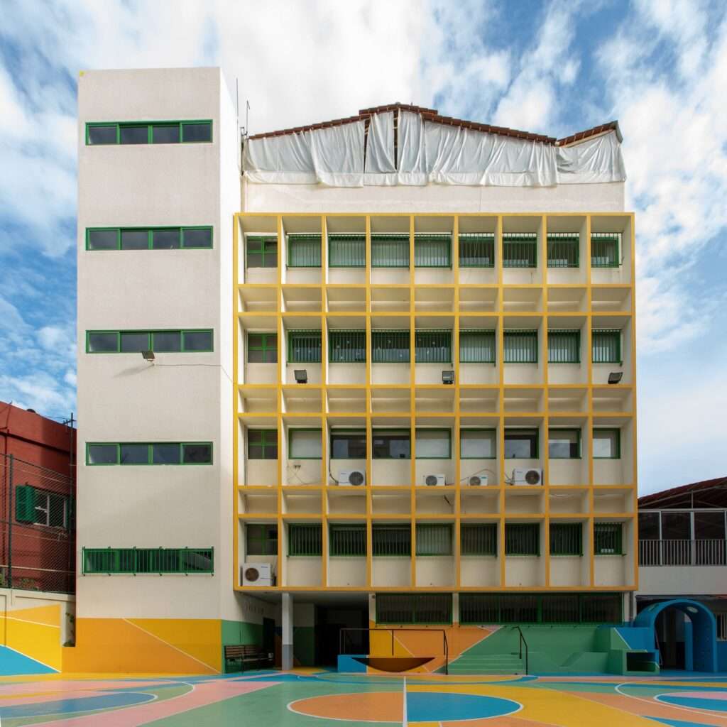 Exterior view of a school building with a colorful ground-level playground in Beirut.