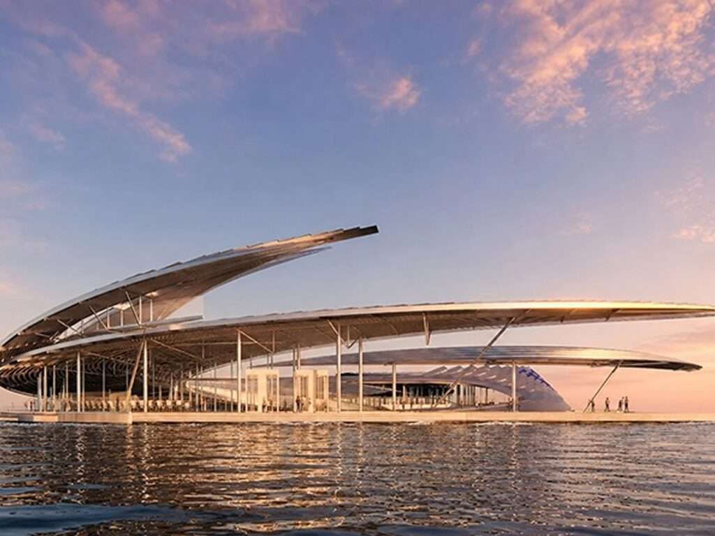 A wide-angle exterior view of the Ocean Vortex structure at sunset, showcasing its modular solar roof and floating configuration.