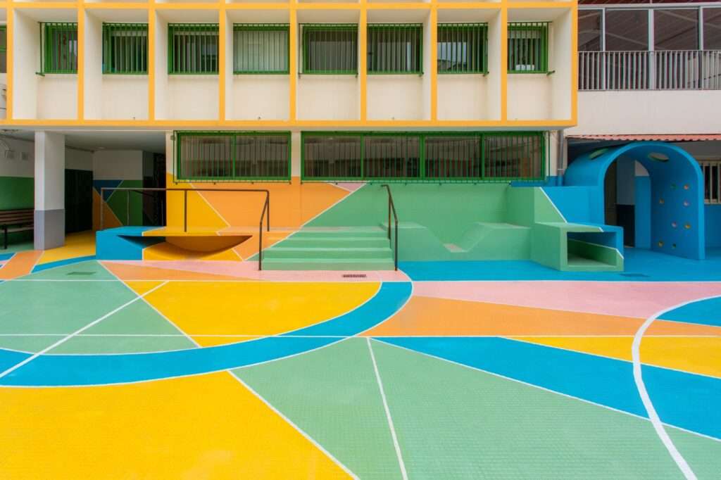 Close-up of playground equipment and painted floor patterns in a school yard.