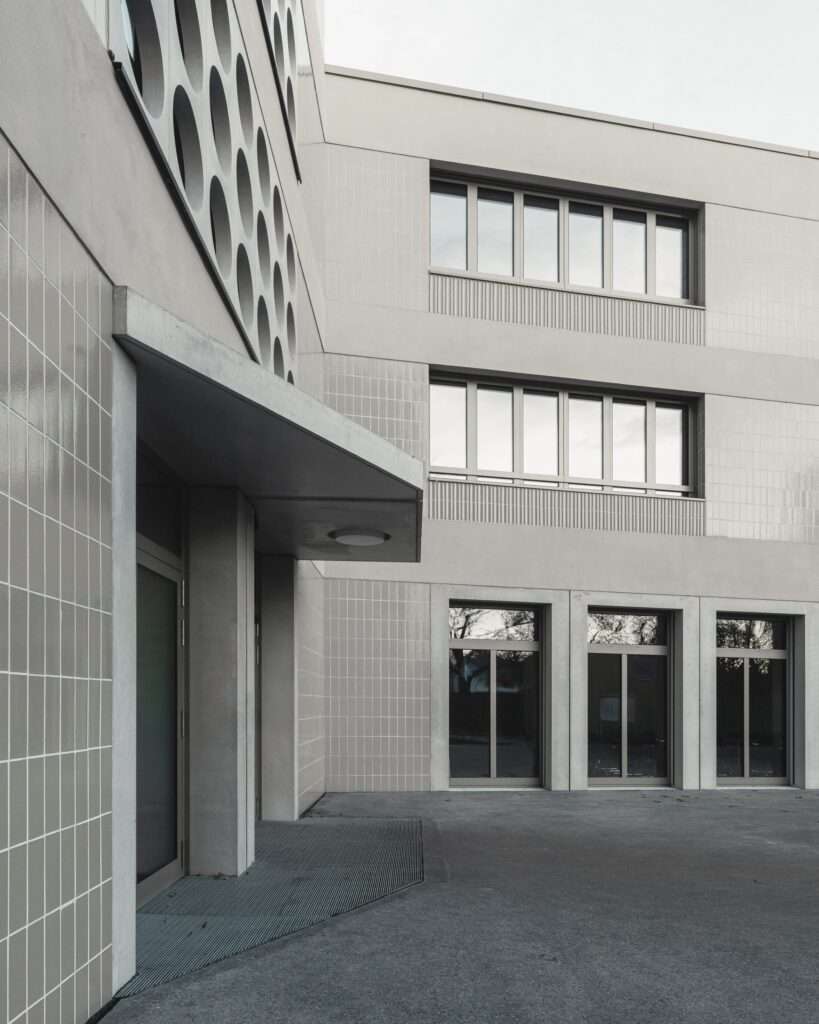 Close-up view of the building entrance and concrete facade details at Lew Tolstoi School.