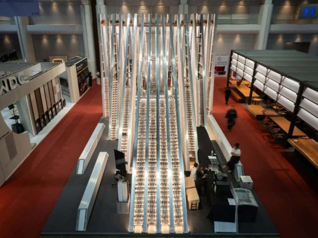 Symmetrical high-angle long shot of the UNFOLD Pavilion stretching across the red-carpeted exhibition floor, filled with integrated linear light tracks.