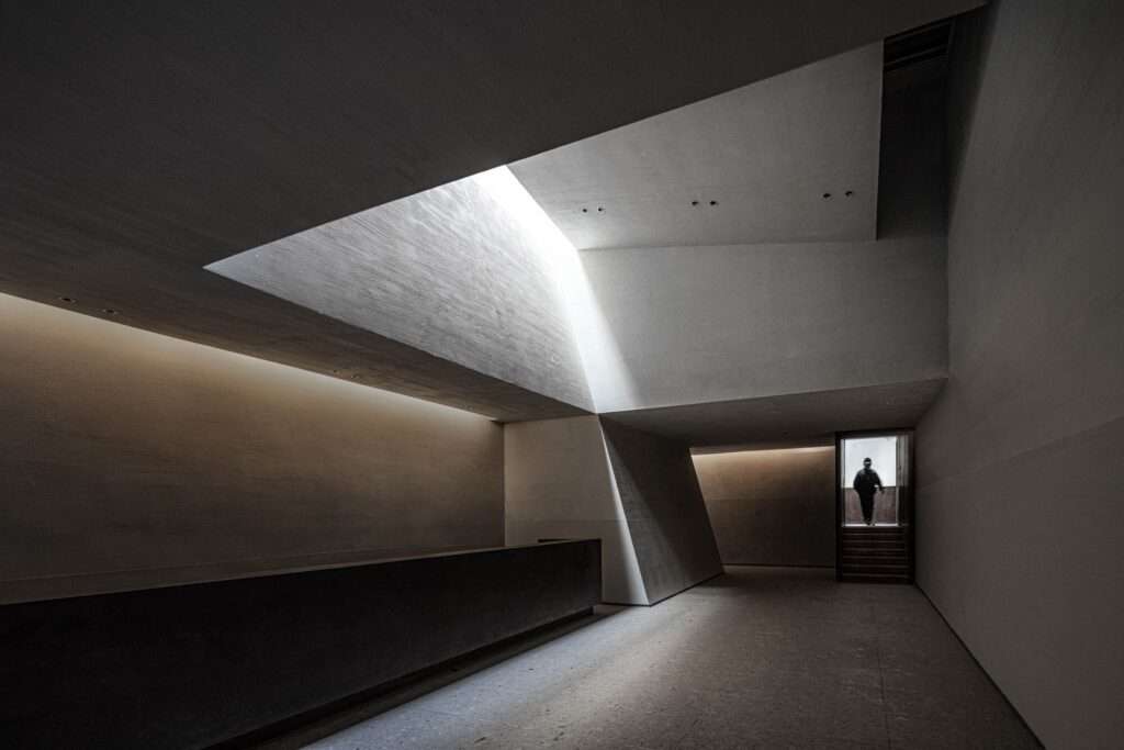 Interior corridor of the Prairie Ark with natural light pouring in from ceiling skylights, creating a dramatic atmosphere.