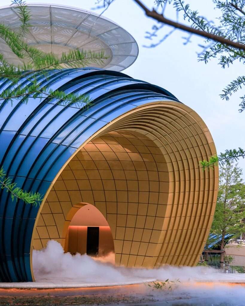 Architectural detail showing the intersection of the golden vaulted underbelly, the blue outer rim, and a perforated white circular disc canopy.