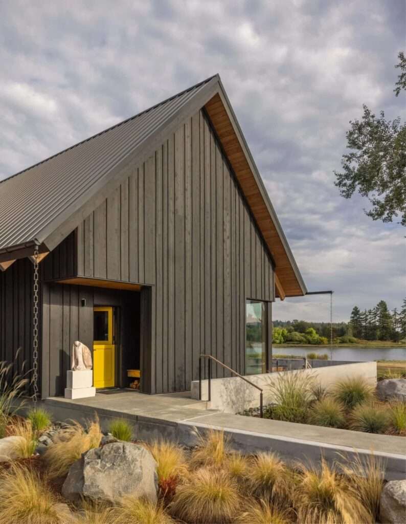 South-facing glass facade of Day's Inlet House featuring solar panels integrated into the gabled roof.