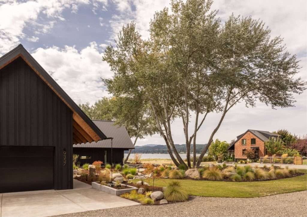 Angular view of the intersecting dark timber wings at Day's Inlet House under an open sky with native landscaping.