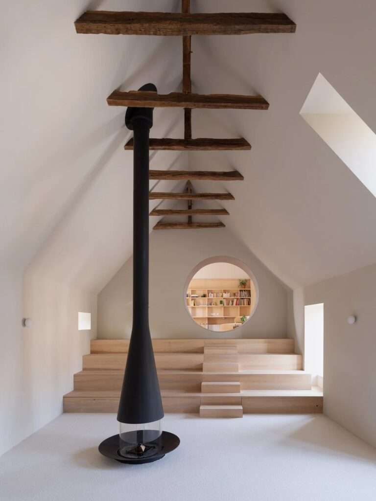 Minimalist corridor interior featuring a seamless light wood flush door, soft beige plastered walls, clean-cut window alcove, and modern sphere wall sconces.
