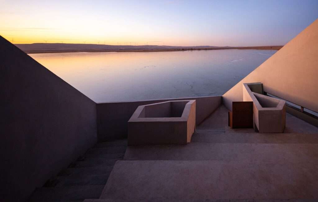 View from a shaded outdoor staircase within the project looking out at the frozen lake and horizon.