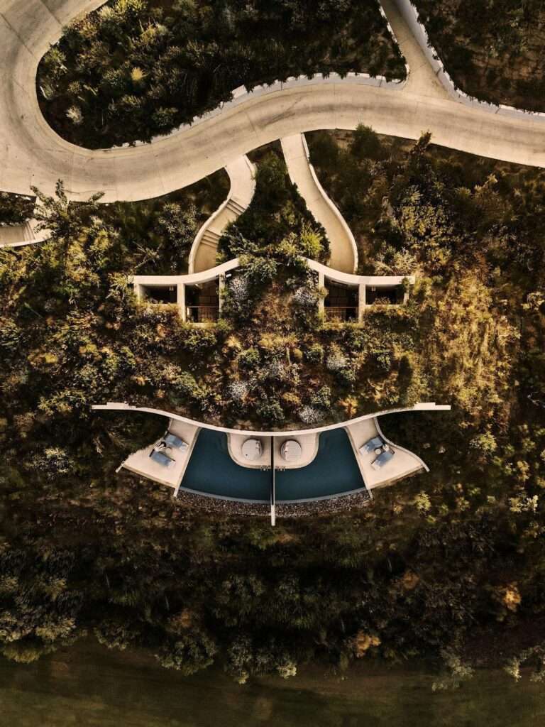 Panoramic drone view of the Mandarin Oriental Costa Navarino resort coastline, golf greens, and terraced structures along Navarino Bay.