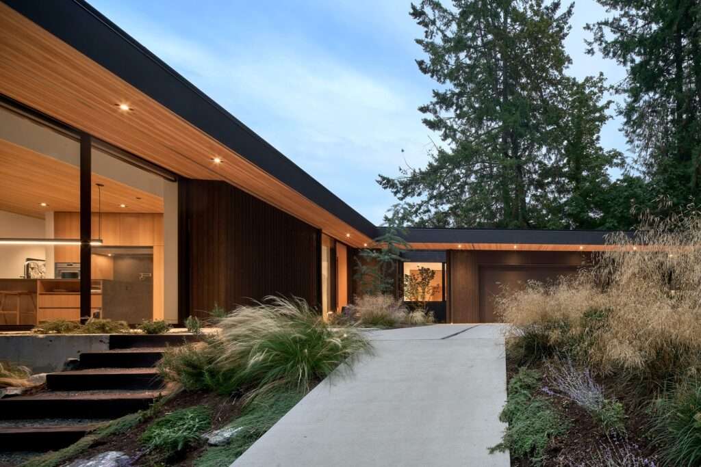 Side view of the sloped pathways and building exterior showing the integration into the forested slope.