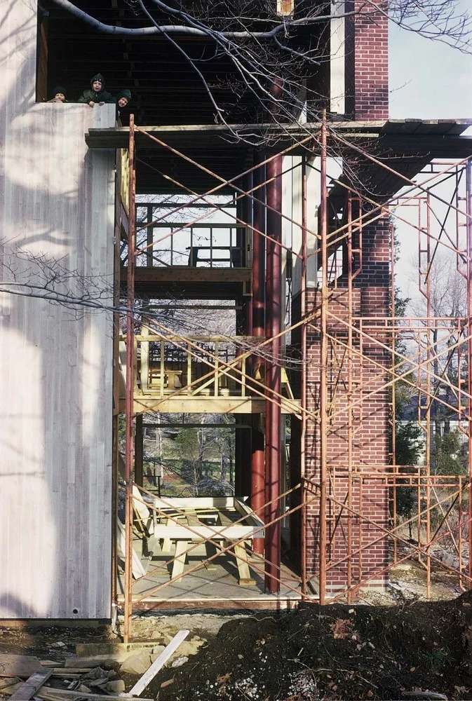 Historical construction photo of the Smith House showing the three-story timber framing and steel structural columns.