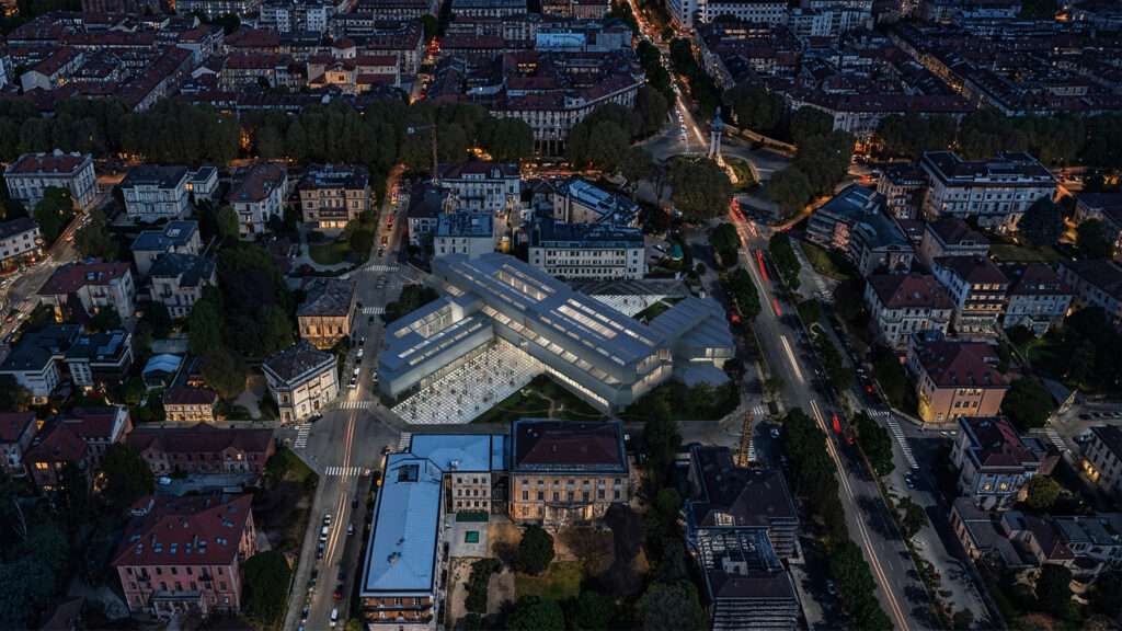 An aerial render of a modern museum volume oriented diagonally within an urban city block at dusk.