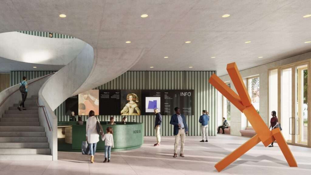 Interior welcome hall with a curved concrete staircase, a green circular reception desk, and informational displays.