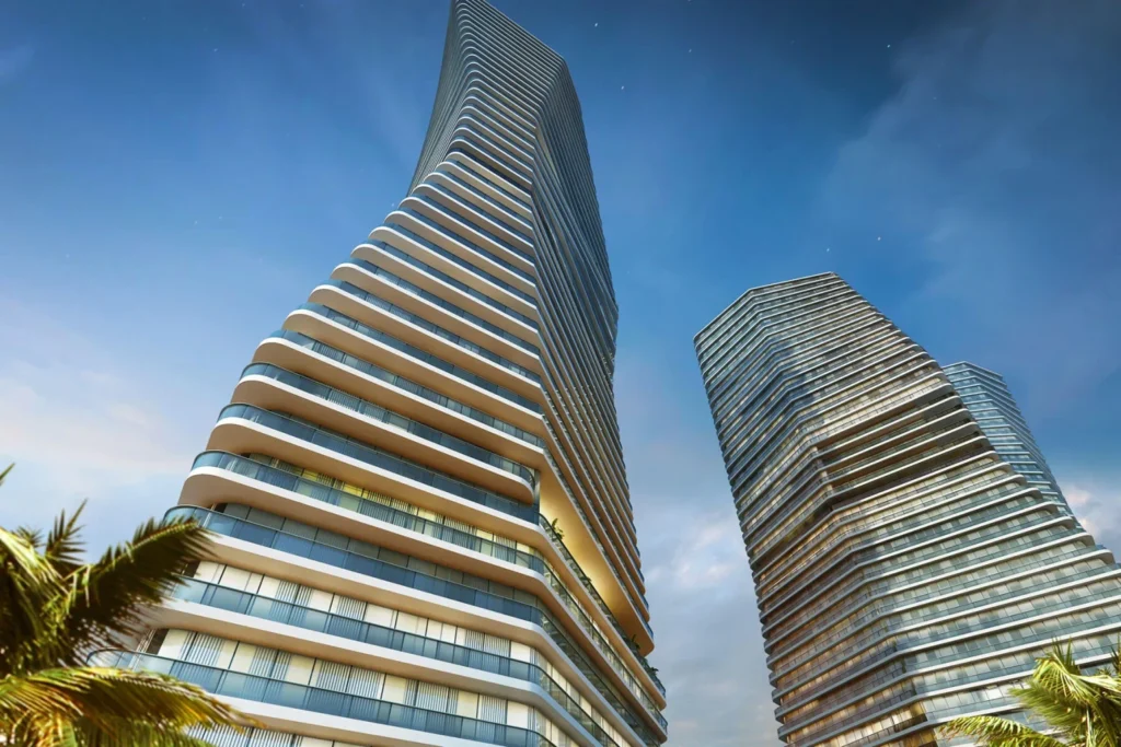 Low-angle view looking up at faceted tower facades with continuous balcony lines.