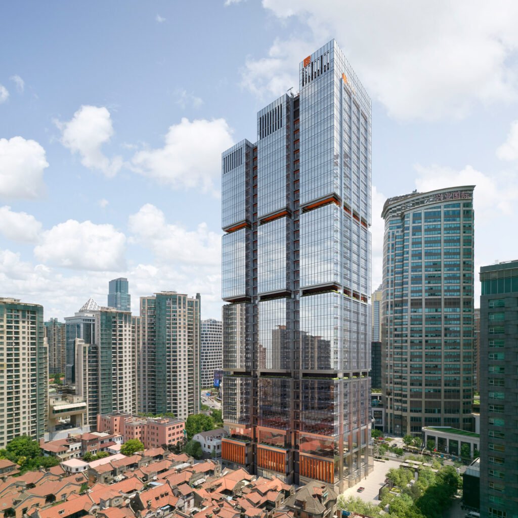 Full view of three-part glazed skyscraper rising above historic low-rise residential roofs in Shanghai.