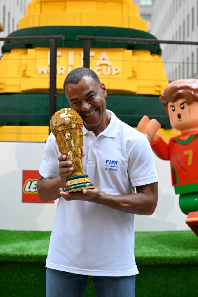 كافو يبتسم وهو يحمل نسخة أصغر مصنوعة من المكعبات لكأس العالم لكرة القدم.