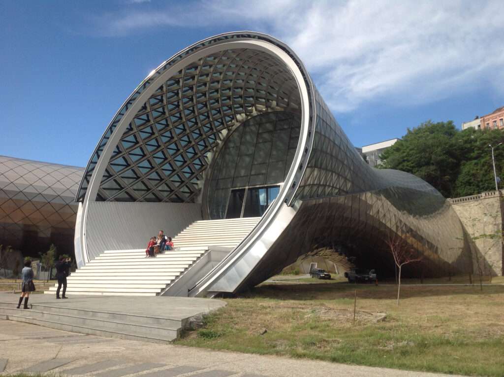A close-up view of the building's entrance featuring large seating steps leading up to a glass door.