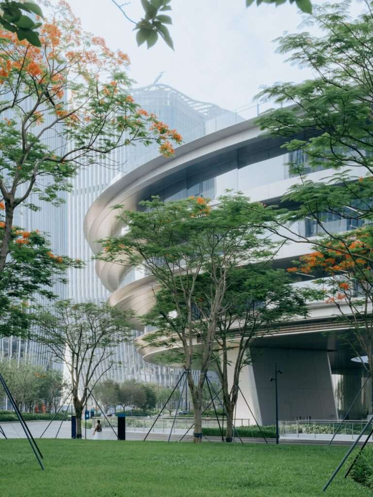 Close-up view of the building's sweeping curved canopy layers behind landscaped trees.