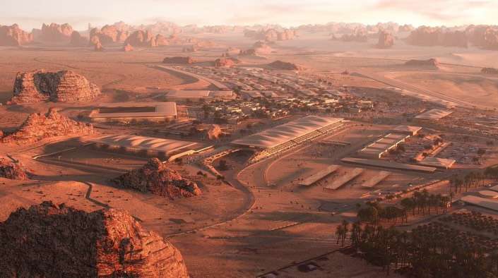 Wide panorama of an extensive desert facility nestled between valley rock formations under warm evening light.