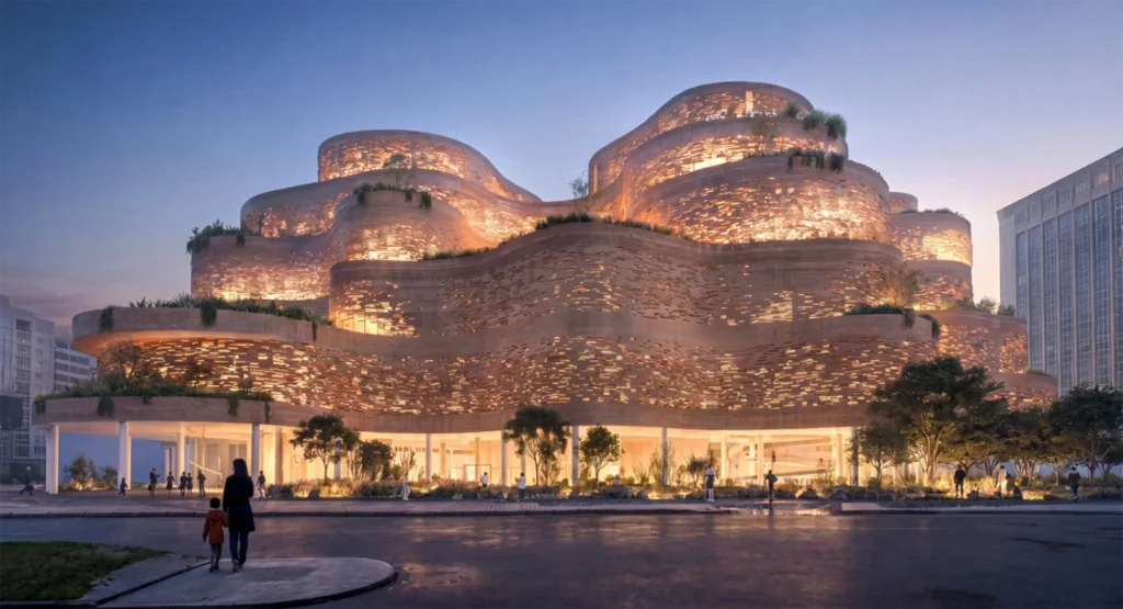 Nighttime exterior view of the terraced museum building with warm light glowing through porous facade openings.