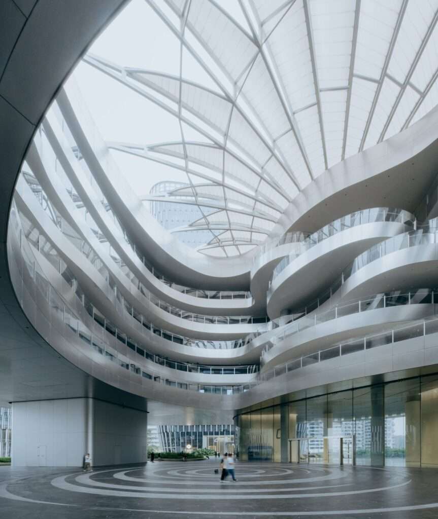 Looking up at the tiered open-air atrium with a semi-open skylight structure.