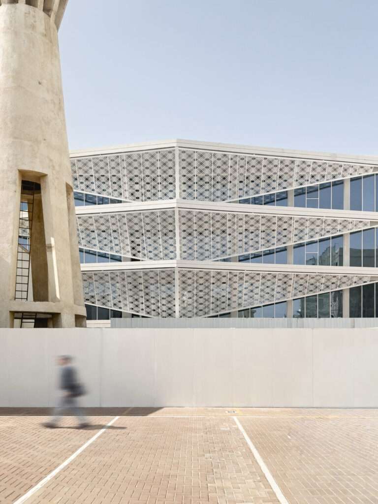 Vertical view showing the Indonesian Consulate building facade integrated with the iconic historic water tower in Jeddah.