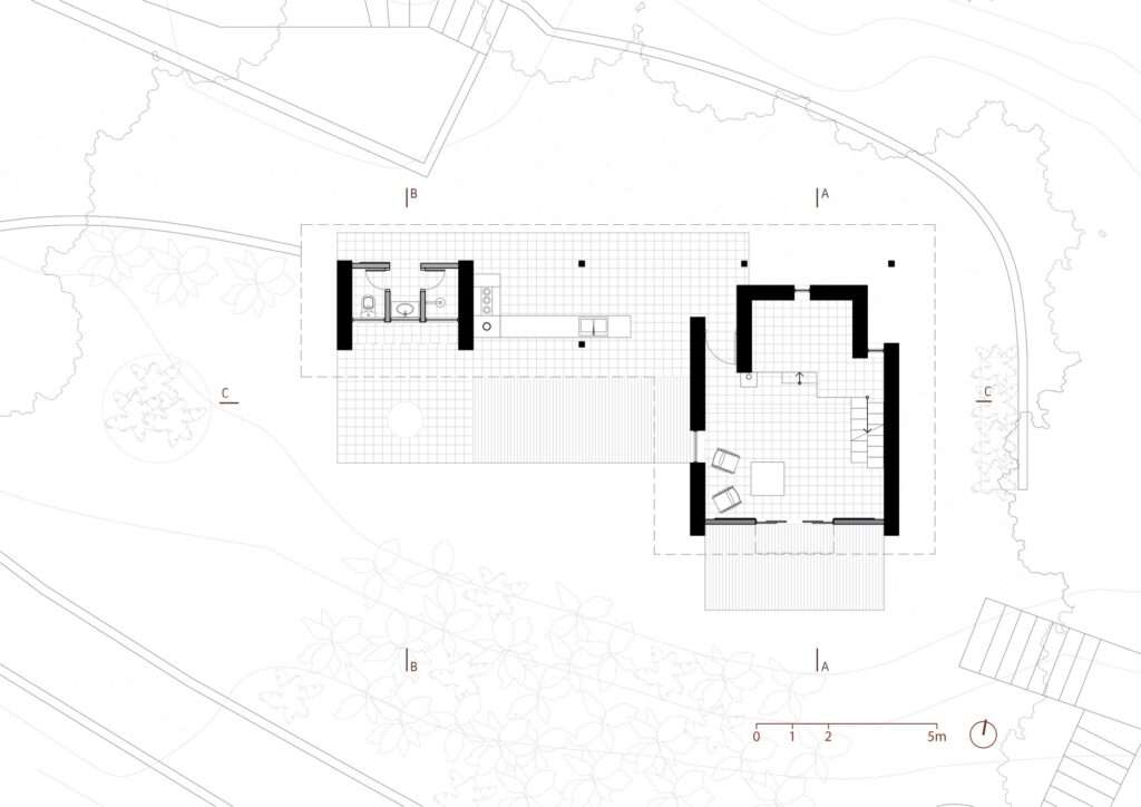 Architectural ground floor plan of the Lake Cabin, illustrating the layout of the living space, kitchen, and sanitary facilities set within the natural landscape.