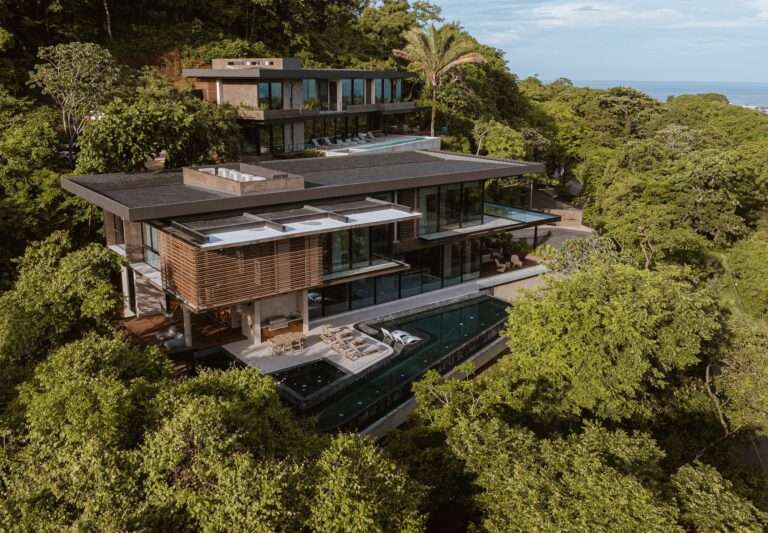 Aerial view of KUL Nosara luxury hillside villas surrounded by dense tropical rainforest and overlooking the ocean.