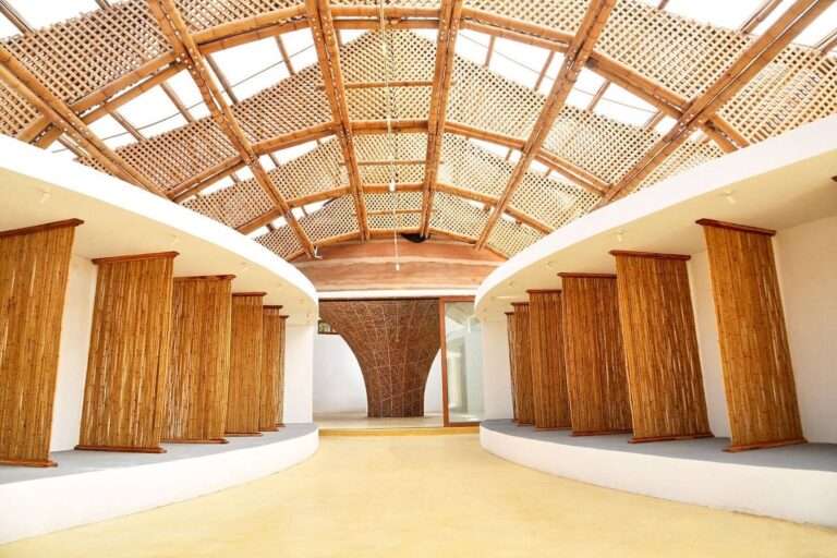 Interior gallery of the Mami Dan Temple featuring bamboo partition screens, light yellow floors, and an intricate woven bamboo ceiling structure.