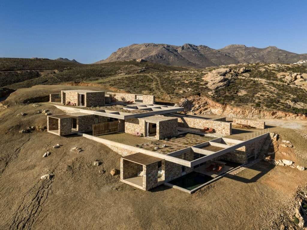 Aerial view of the Perma project in Serifos, showing stone residential blocks integrated into the natural rocky slope.