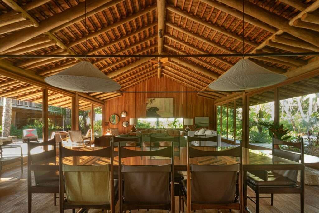 Spacious open-plan interior dining area under a exposed timber gabled roof with woven pendant light fixtures.
