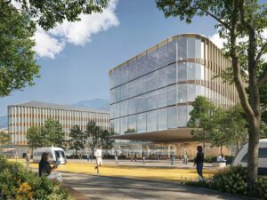 Modern hospital architecture in Brescia featuring glass facades, an integrated yellow transit pathway, and people walking through an open campus layout.