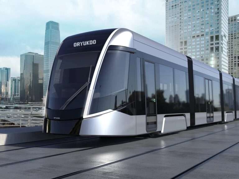 Futuristic silver and black Oryukdo tram with a curved aerodynamic front facade gliding on tracks against a modern city skyscraper skyline background.