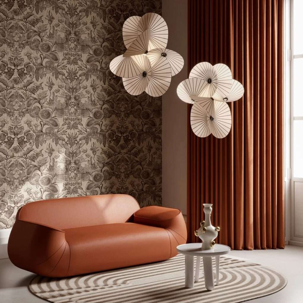 Modern low-profile orange leather sofa paired with unique fan-shaped white pleated pendant lamps against a highly detailed damask wallpaper.