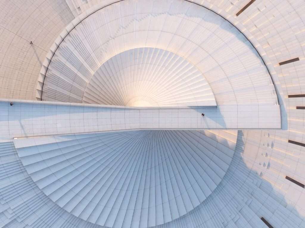 Top-down aerial view of the Shanghai Grand Opera House’s spiral roof structure and pedestrian bridge.
