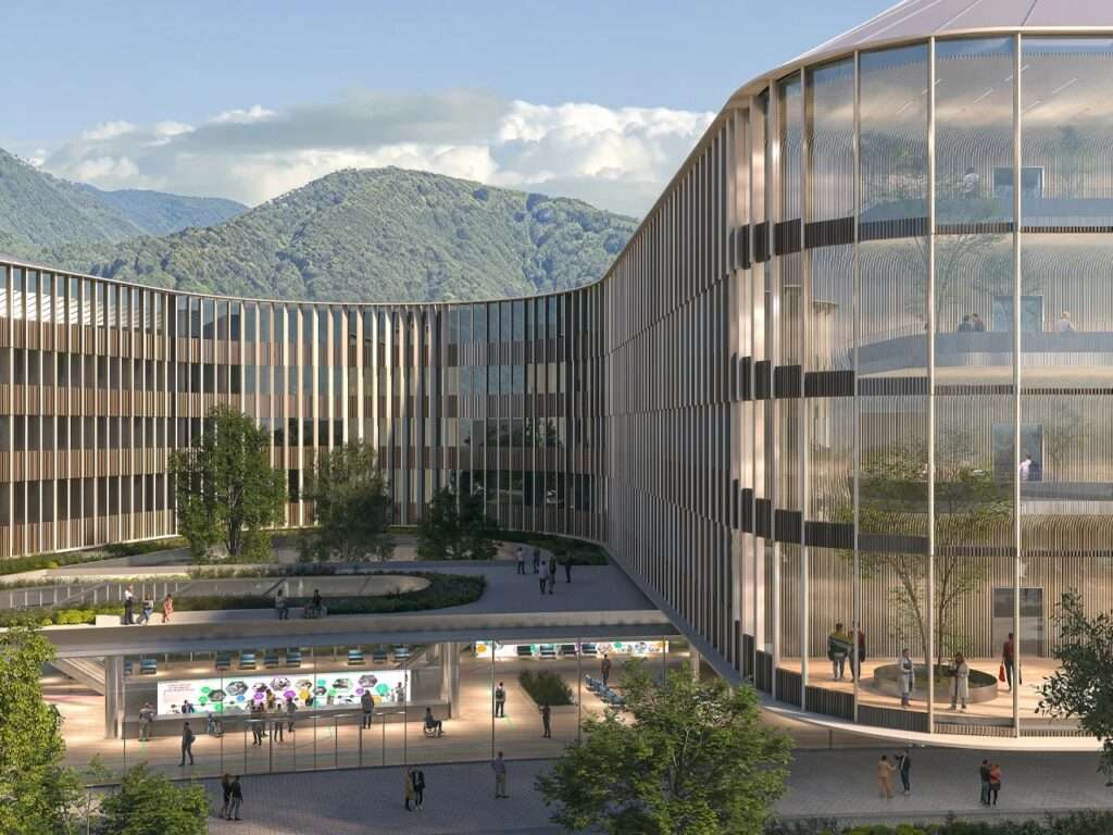 Curved linear wing of Brescia hospital overlooking an open public pavilion with a backdrop of green mountains.