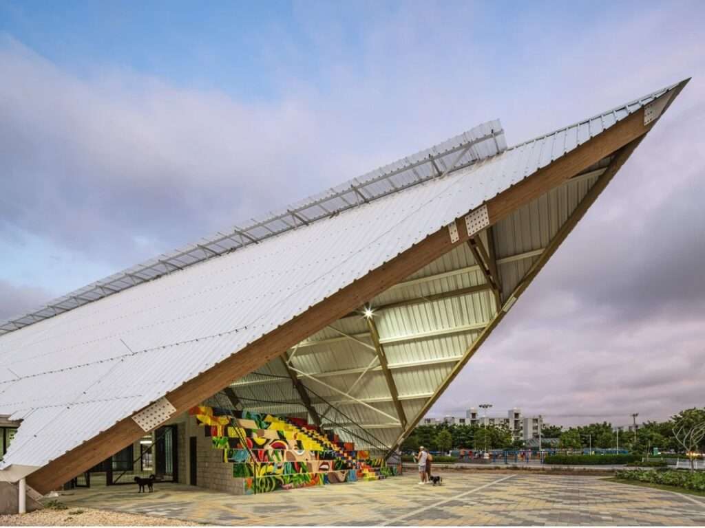 Sharp cantilevering point of the white metal roof at the Vilas de San Pablo Cultural Center over an outdoor amphitheater.